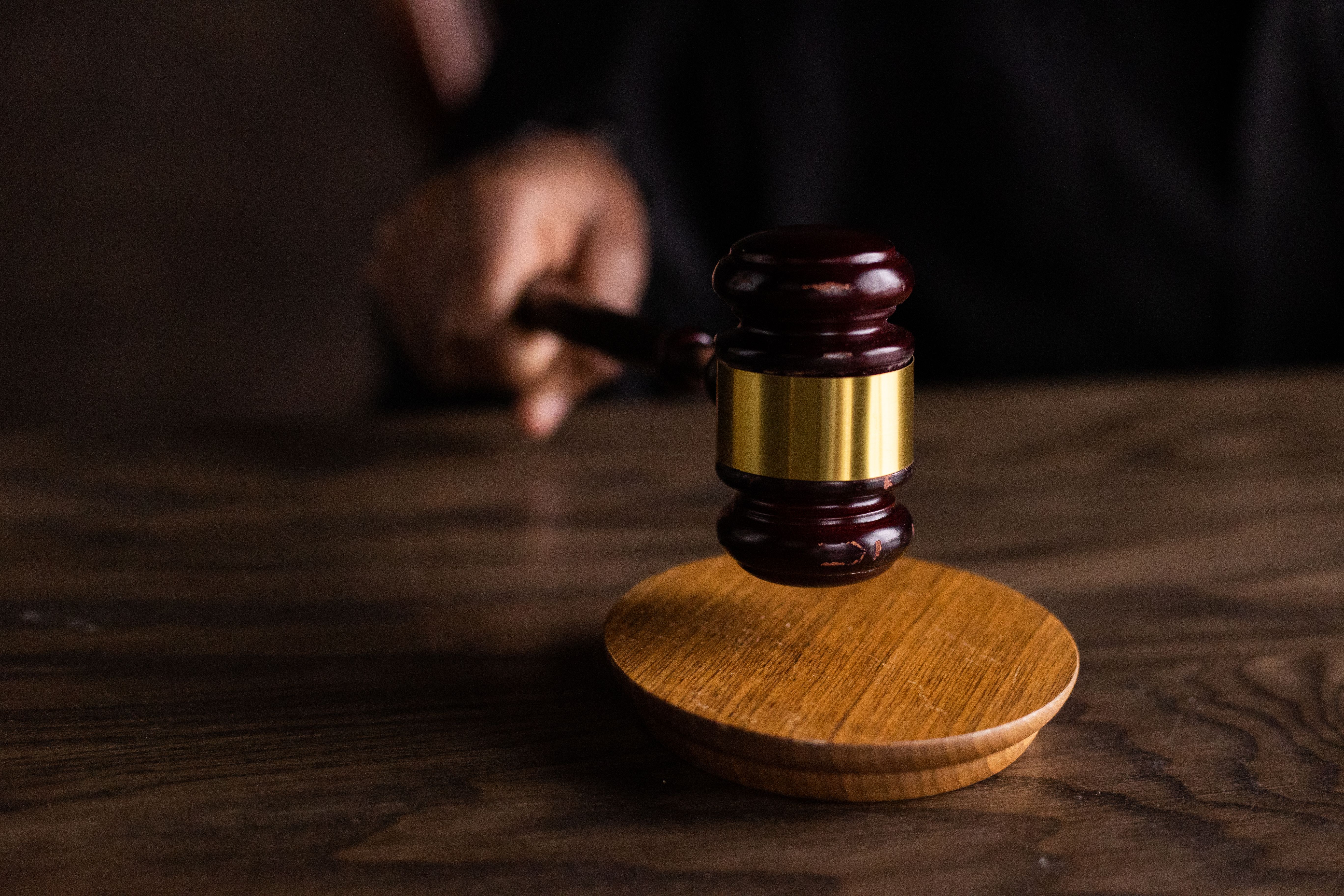 Gavel striking a sound block in a courtroom, representing rulings and judgments in complex litigation